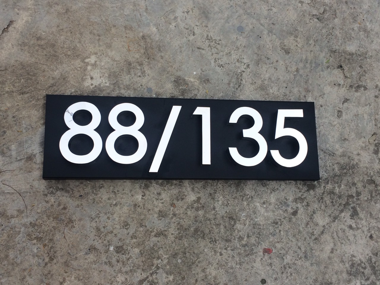 ป้ายบ้านเลขที่ 88/135 ติดตั้งบนฐานสีดำด้าน